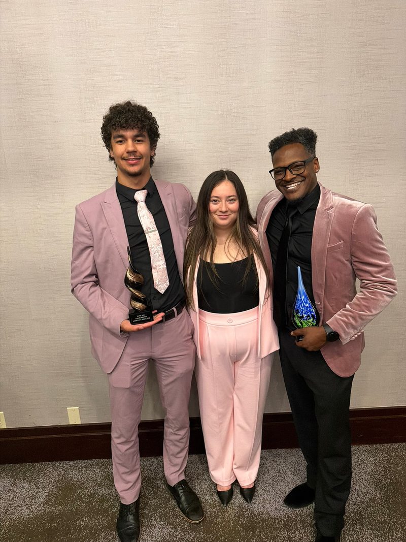 Three Chosen Innovations team members holding glass awards at a recognition dinner